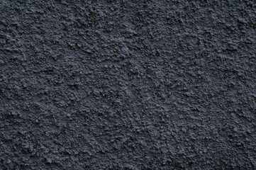 Background of a wall, evenly covered with dark gray plaster.