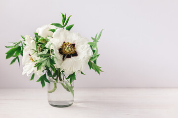 Naklejka na ściany i meble Romantic bouquet of a white peonies in a vase on a white background.