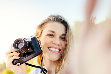 Happy young tourist smiling with sunglasses and camera