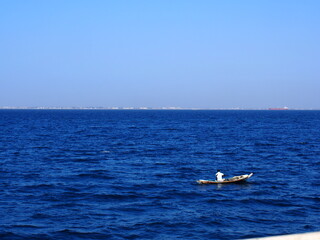 Fototapeta na wymiar Senegalese on a small boat with a blue sea, Goree Island, Dakar, Senegal