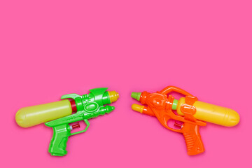 toy water pistols on pink background