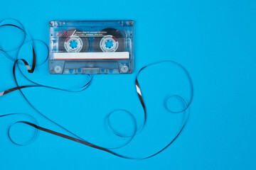 Broken 90's cassette on blue background and with blank label to write on it