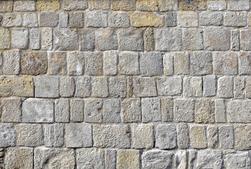 Unique texture of an ancient wall made of uneven bricks 