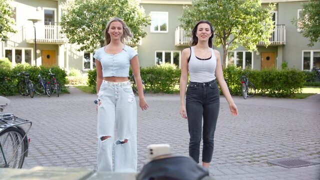 Two friends recording a TikTok dance video together.