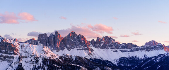 Panorama of a colored winter mountain landscape in South Tyrol, Italy during sunset in winter with the snow covered Seceda mountains