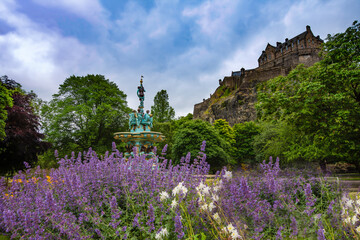 view of Edinburgh castle from princess street gardens. ross fountain and flowers of the gardens with views to the castle beyond. Edinburgh, Scotland.