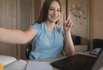 Happy teenager girl smiling on video call phone, taking selfie on smartphone, internet conference, home education and learning to school college. Emotions of happiness braces on teeth.