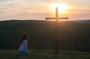 Prayer. Repentance. A woman is kneeling. Near the cross. Prayer of repentance. Christian faith....