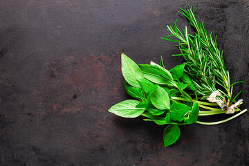 two bunches of rosemary and basil on old rustic background