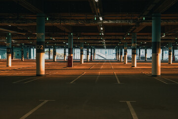 An empty covered  Parking lot with blue license plates lit up by the setting sun