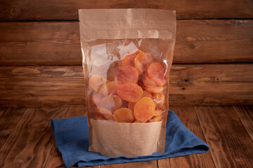 Organic dried fruits - dried apricots in craft eco packaging on a textural design background and...