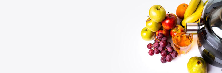 Modern electric juicer, various fruit and glass of freshly made juice, healthy lifestyle concept.