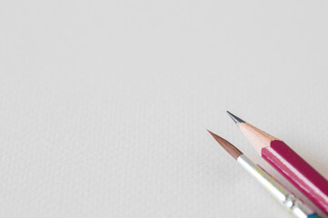 paint brush and pencil on white painting paper.