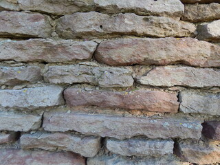 Wall of flat natural stones without facing, interesting texture