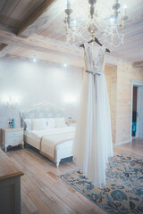 Fototapeta na wymiar White wedding dress hanging on a chandelier