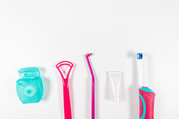 Dental products for brush teeth, healthy teeth care and oral hygiene. Ultrasonic pink toothbrush and dental hygiene products on grey background