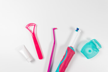 Ultrasonic pink toothbrush and dental hygiene products on a grey background