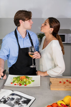 Young couple at the kitchen about to kiss