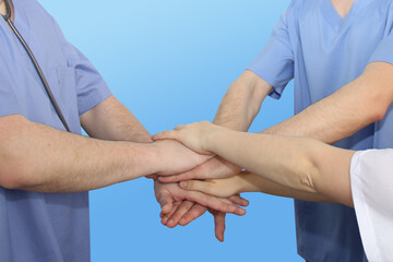 three doctors joined hands in a sign of support and mutual assistance, the concept of medical...