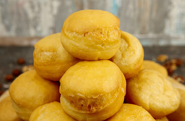 Baursaki is a traditional pastry of national oriental cuisine. On a wooden plate, on a gray textured background