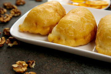 Fresh aromatic pastries for breakfast or snack on a square white plate, 
a cup of tea with lemon