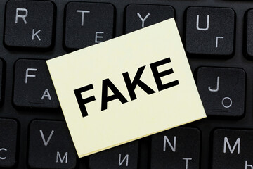 FAKE word concept on sticker on the keyboard