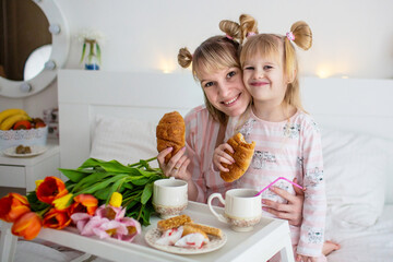 mother with daughter in a white bedroom