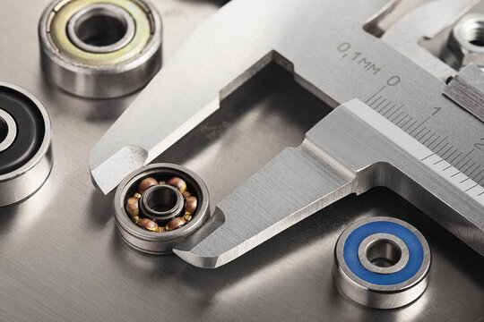 vernier caliper measures bearings against a metal background. Part of the mechanism.