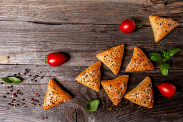 Samsa or samosas with meat and vegetables on rustic background, top view. Traditional Indian food. Copy text
