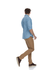 casual guy in denim shirt looking to side and walking