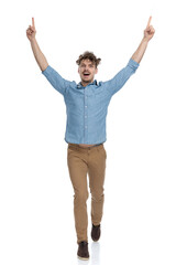 enthusiastic casual man pointing fingers in the air and celebrating