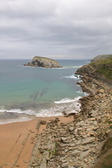 photo of beach with rocks in cloudy day