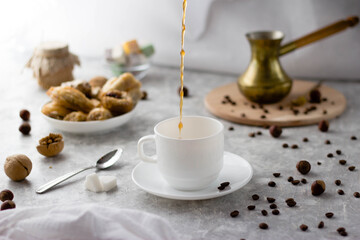Obraz na płótnie Canvas Coffee is poured into a white mug with a splash