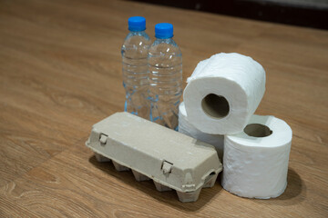Toilet paper with raw egg panel and drink water bottle on the house floor, Donation concept.