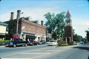 Obraz premium Trafic on the picturesque Queen street of a Canadian touristic destination town Niagara-on-the-Lake with Clock Tower.