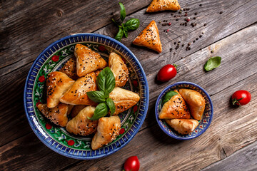 Uzbek and Central Asia cuisine concept. Samsa or Sambousak in national plate. Samsa or Sambousak an oriental meal to be stuffed with minced meat, cheese or vegetables