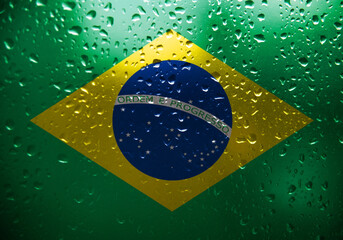 Texture of Brazil flag on the glass with drops of rain.