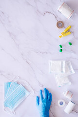 Flat lay of some medical supplies against a white marble background