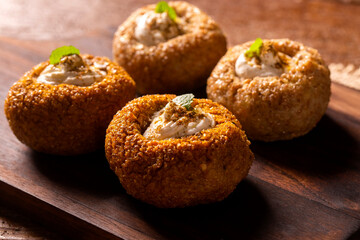 kibe stuffed with dry curd on wood background.