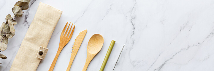 Set of Eco friendly bamboo cutlery on white marble background. Sustainable lifestyle. Plastic free concept. Flat lay, top view, mockup