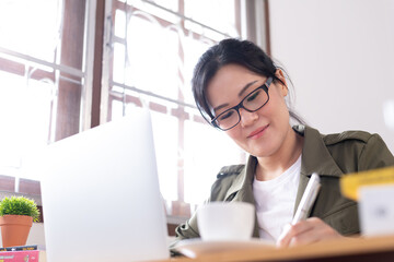 Modern young Asian woman working from home.