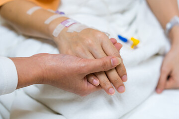 Obraz na płótnie Canvas hand hold a patients hand on bed in hospital