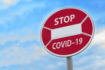 Stop road sign stylized as a medical mask with the inscription 