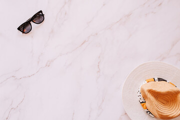 Flat lay of objects related to summer, spring and leisure against a marble background
