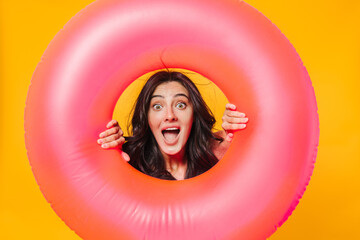 Image of excited woman posing with rubber ring expressing surprise