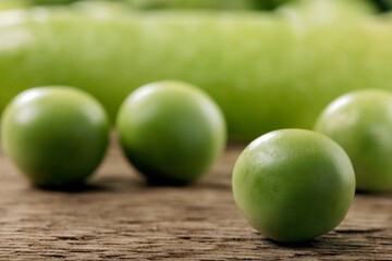 Close up of freshly picked peas on a wooden table.