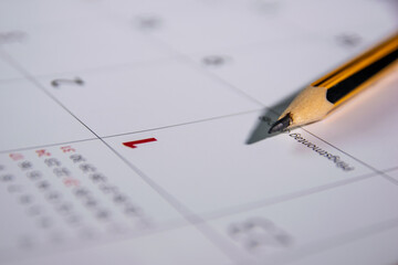 a pencil lies on an open calendar indicating the first day of the month.