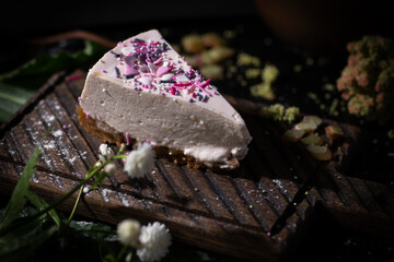 Homemade cheesecake. Slice of tasty plain cheesecake on wooden background