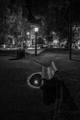 Piekny, nastrojowy widok nocnego parku z lawka, latarnia i jej odbiciem © Jerzy