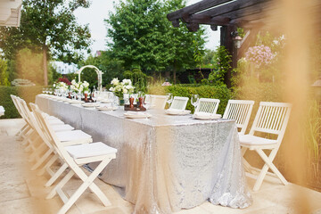 White table with blooming flowerpots before celebrating a birthday in a green park